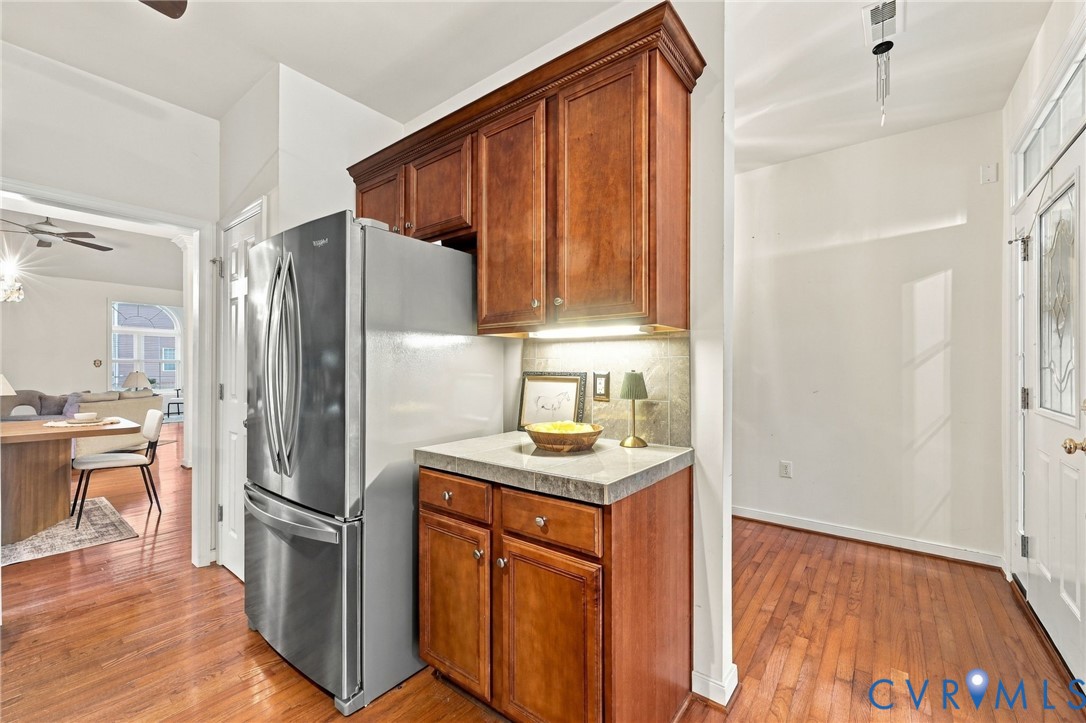Wood-finish flooring throughout, featuring a kitchen area with wood cabinetry, under-cabinet lighting, and a countertop