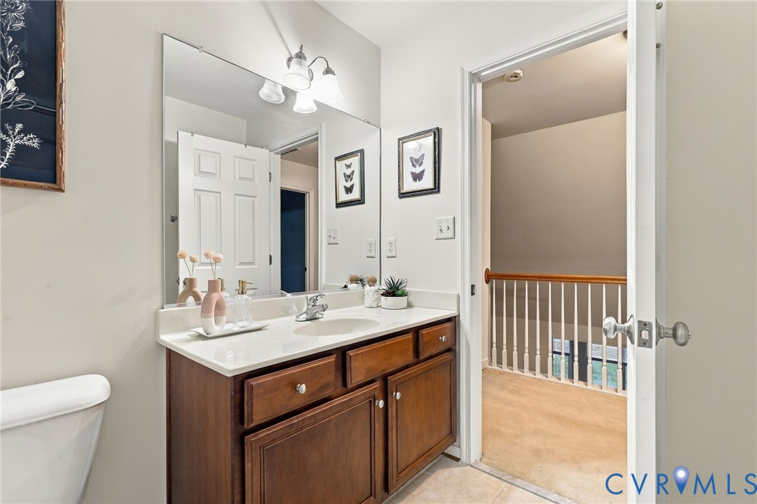 Spa-inspired primary bathroom featuring a wood-finish vanity with dual drawers and cabinet storage, white quartz countertop, and chrome fixtures
