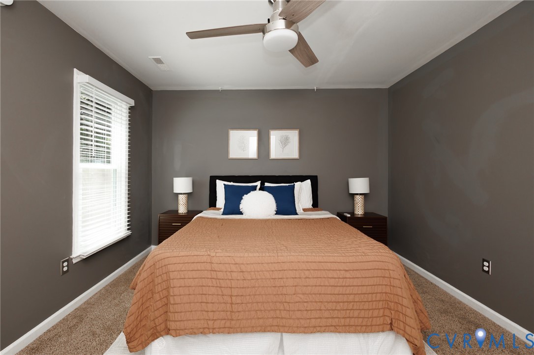 Plush carpeting, neutral wall tones, and a ceiling fan with integrated lighting