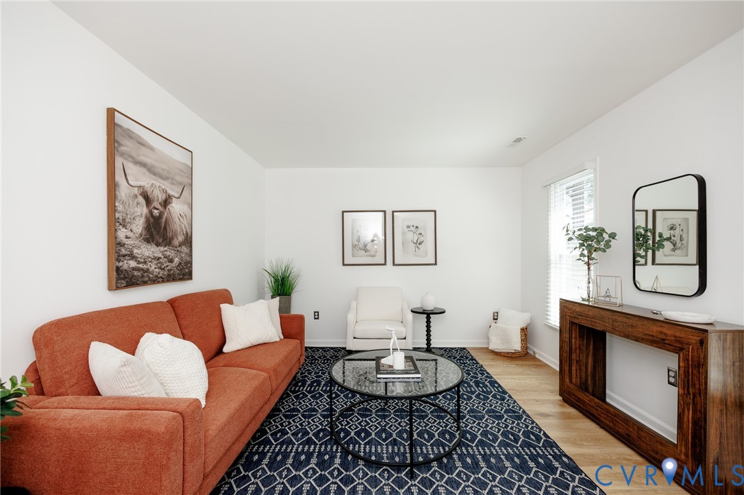 Wood-finish flooring, white walls, and a window with blinds