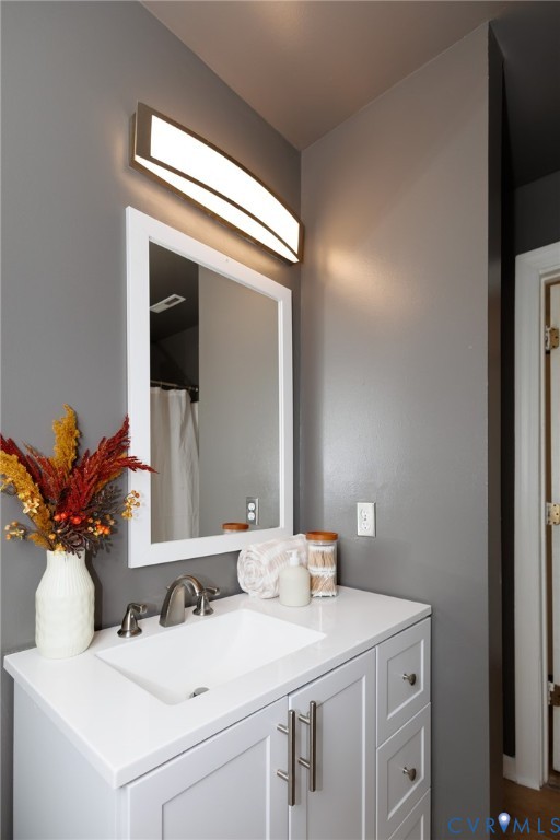 White vanity with shaker-style cabinetry, an integrated sink, and brushed nickel hardware