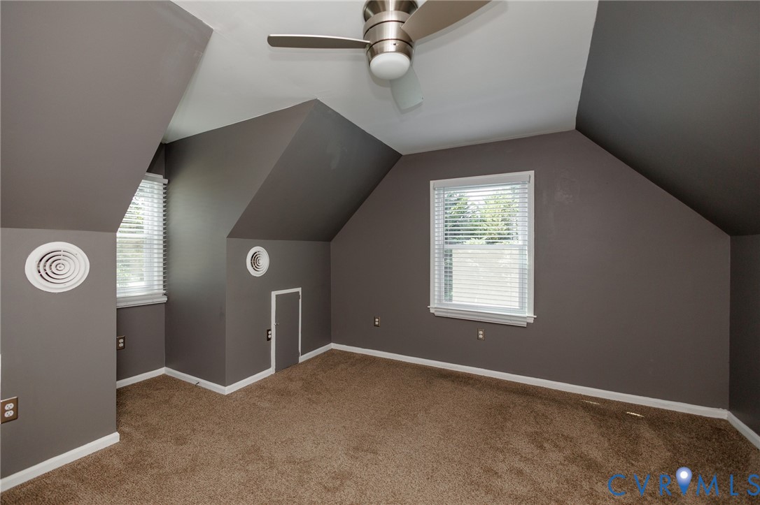 Carpeted flooring with multiple windows and a ceiling fan