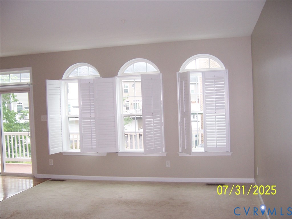 Carpeted spare room featuring baseboards