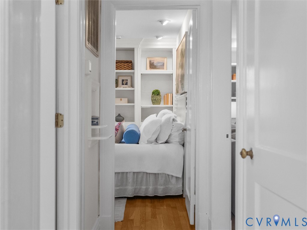 Hardwood-finish flooring, built-in shelving, recessed lighting, and white trim
