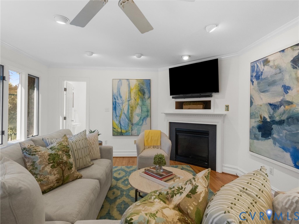 Hardwood flooring, recessed lighting, and a built-in fireplace with a mantel
