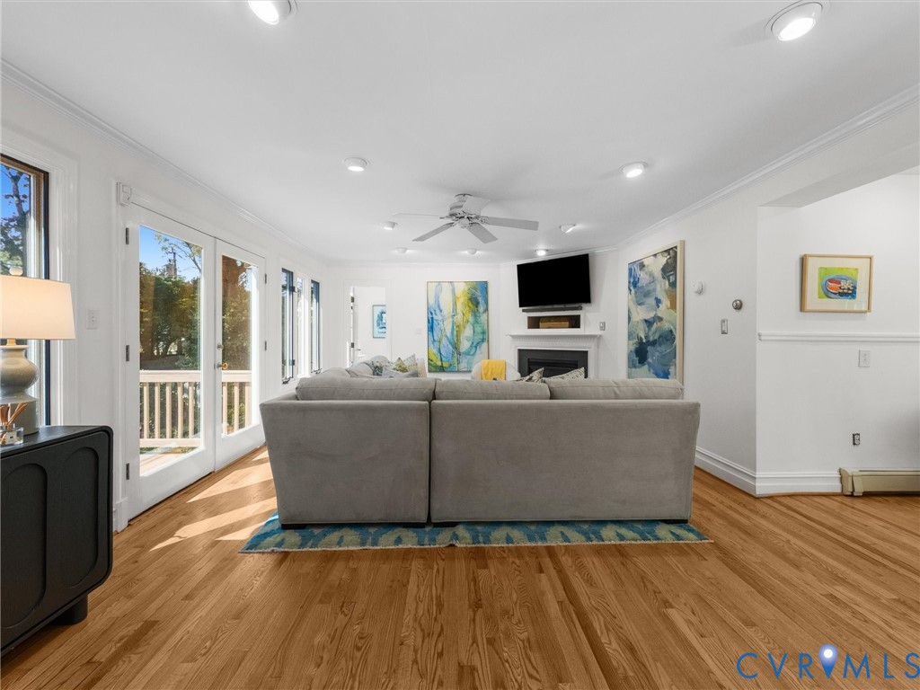 Hardwood flooring throughout, recessed lighting, ceiling fan, and French doors leading to an outdoor deck with white railings