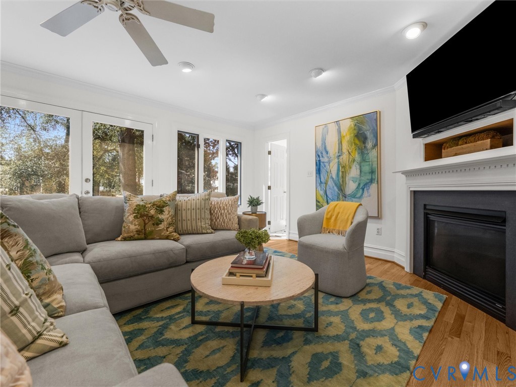 Living area featuring a fireplace with classic white mantel, wood-finish flooring, recessed lighting, and a ceiling fan