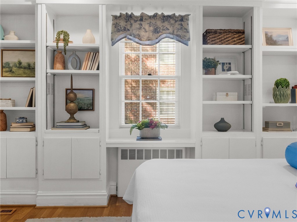 Built-in shelving with adjustable shelves, integrated cabinetry, and a double-hung window