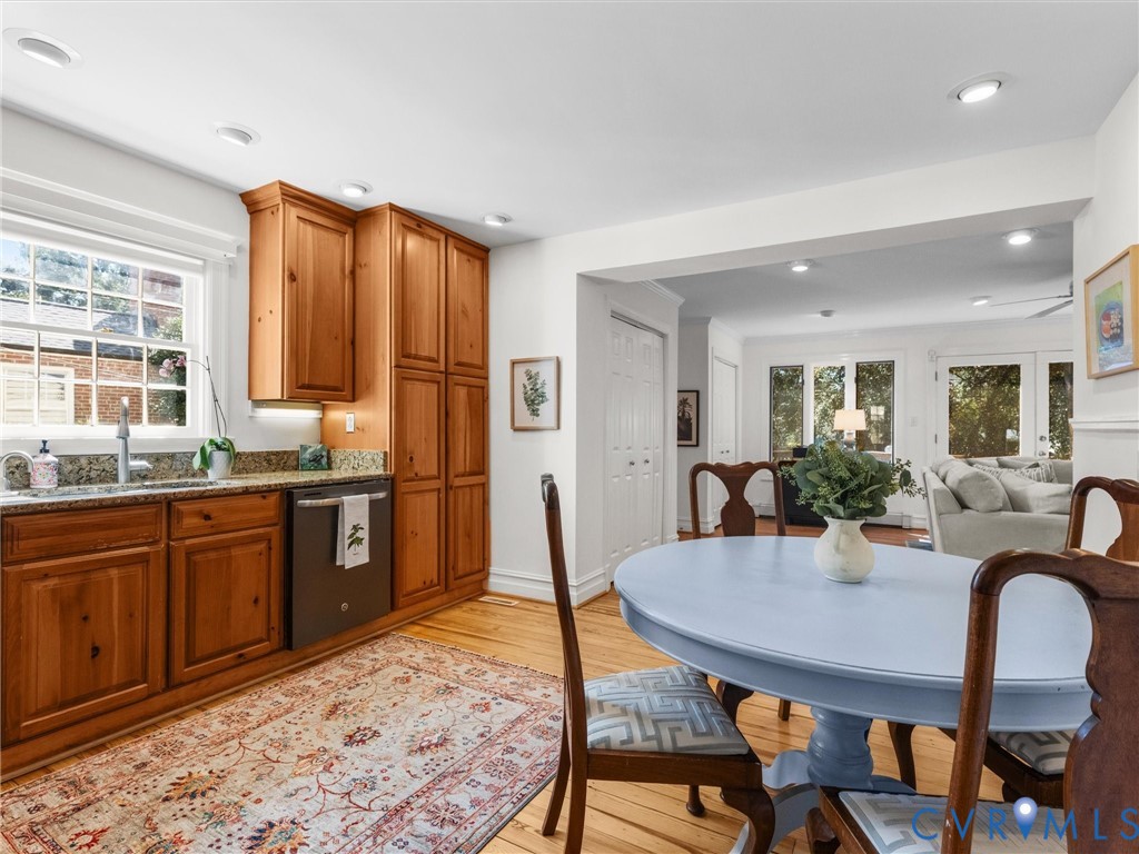 Recessed lighting, wood-finish flooring, wood cabinetry, granite countertops, and a stainless steel sink with a gooseneck faucet