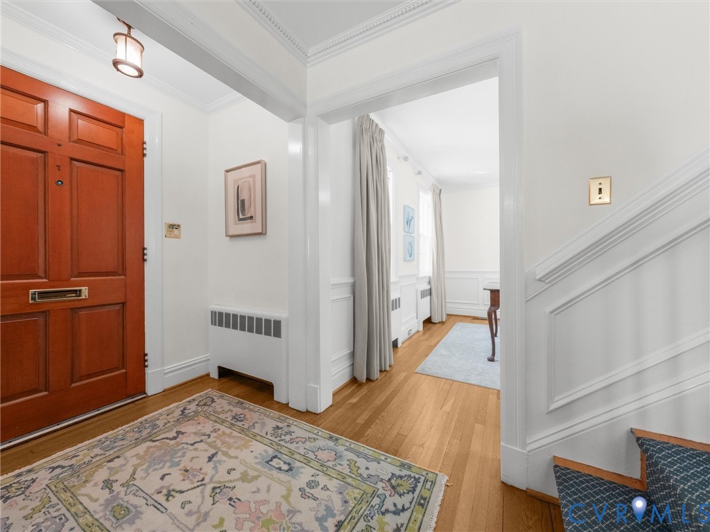 Hardwood flooring and detailed crown molding enhance this entryway