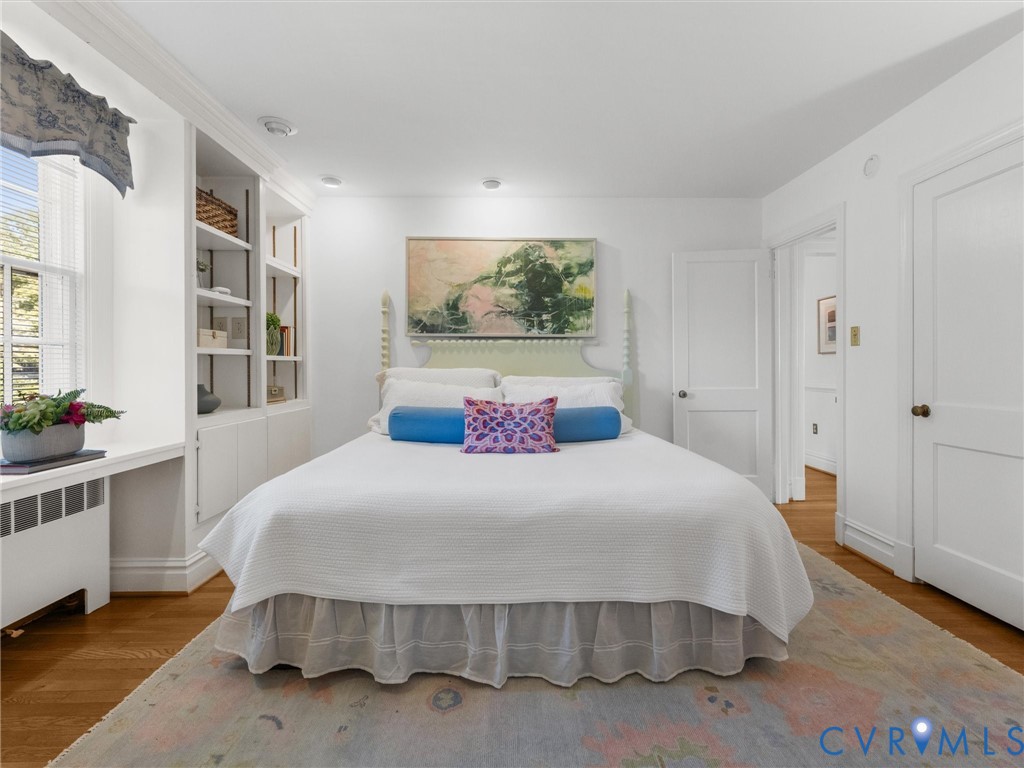 Hardwood flooring, built-in shelving, built-in desk, recessed lighting, and white paneled doors