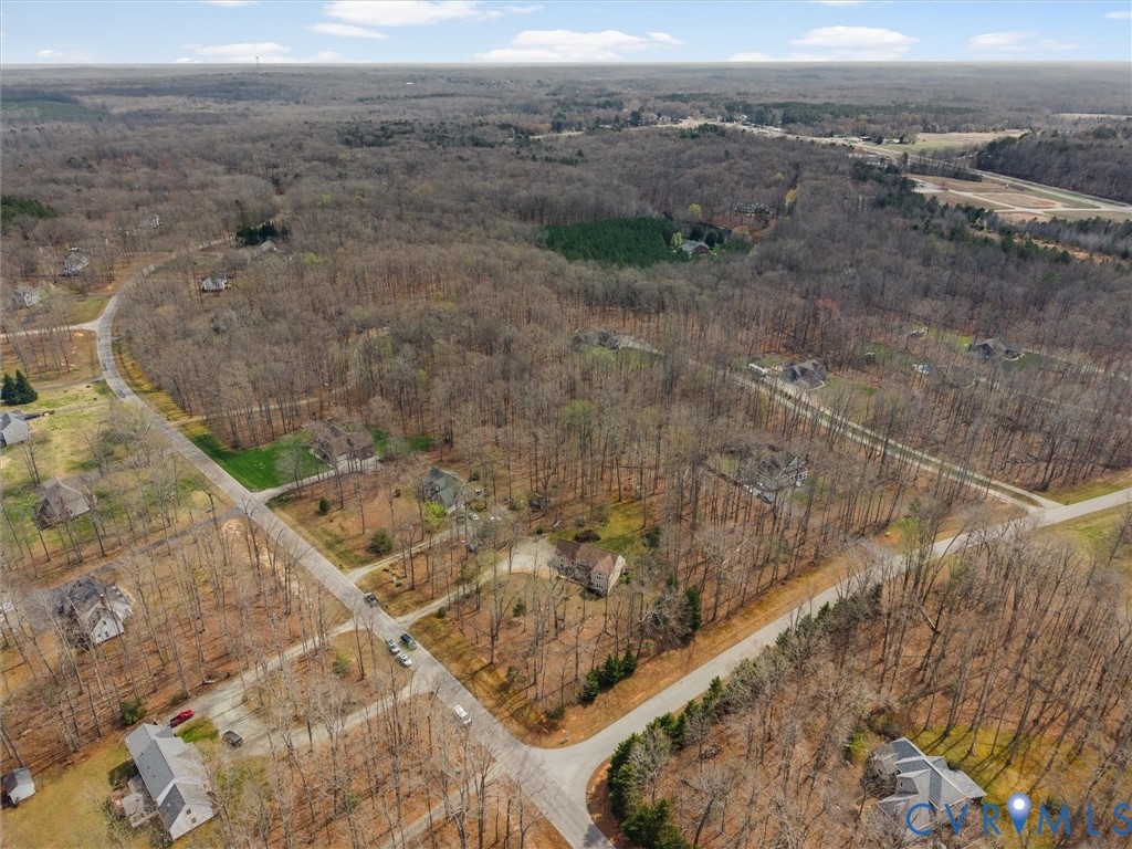 Expansive wooded landscape featuring a network of paved roads and scattered residential properties