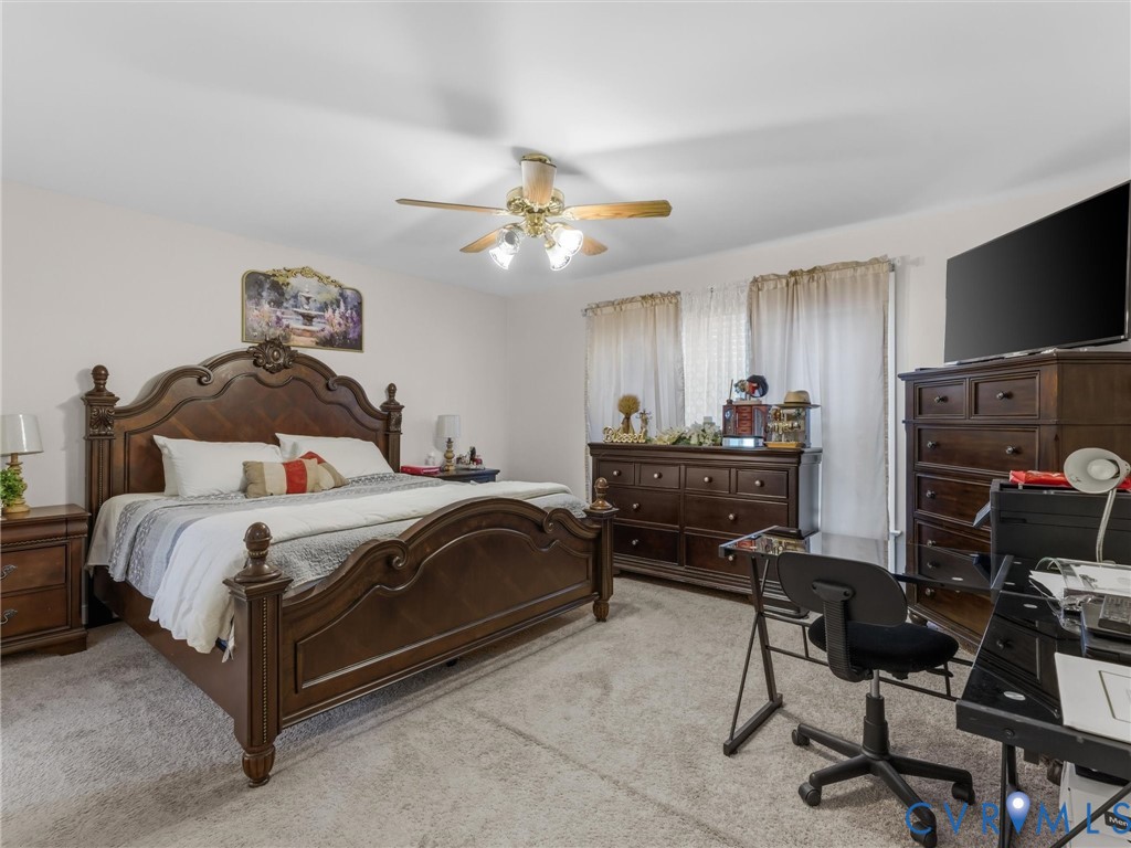 Carpeted bedroom with a ceiling fan, dual windows, and ample wall space Carpeted bedroom with a ceiling fan, dual windows, and ample wall space