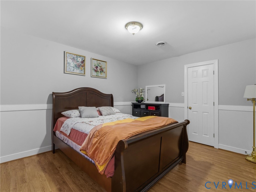 Wood-finish flooring, white paneled door, and recessed ceiling light fixture