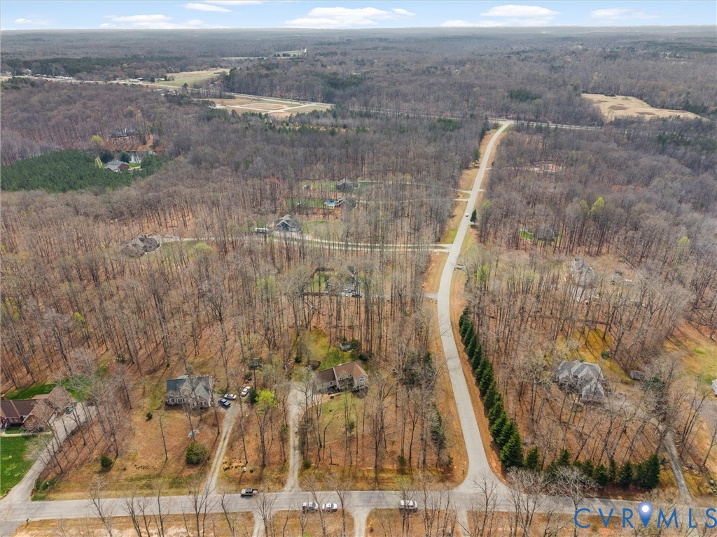 Extensive wooded surroundings, established paved roads, and scattered residential properties