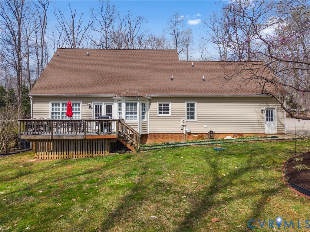 Expansive rear decking, multiple egress points, bay window, and a natural wood-finish door