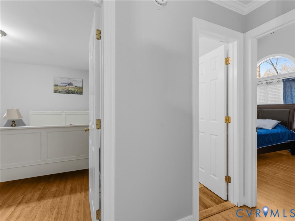 Solid wood flooring throughout, paneled interior doors, and arched window