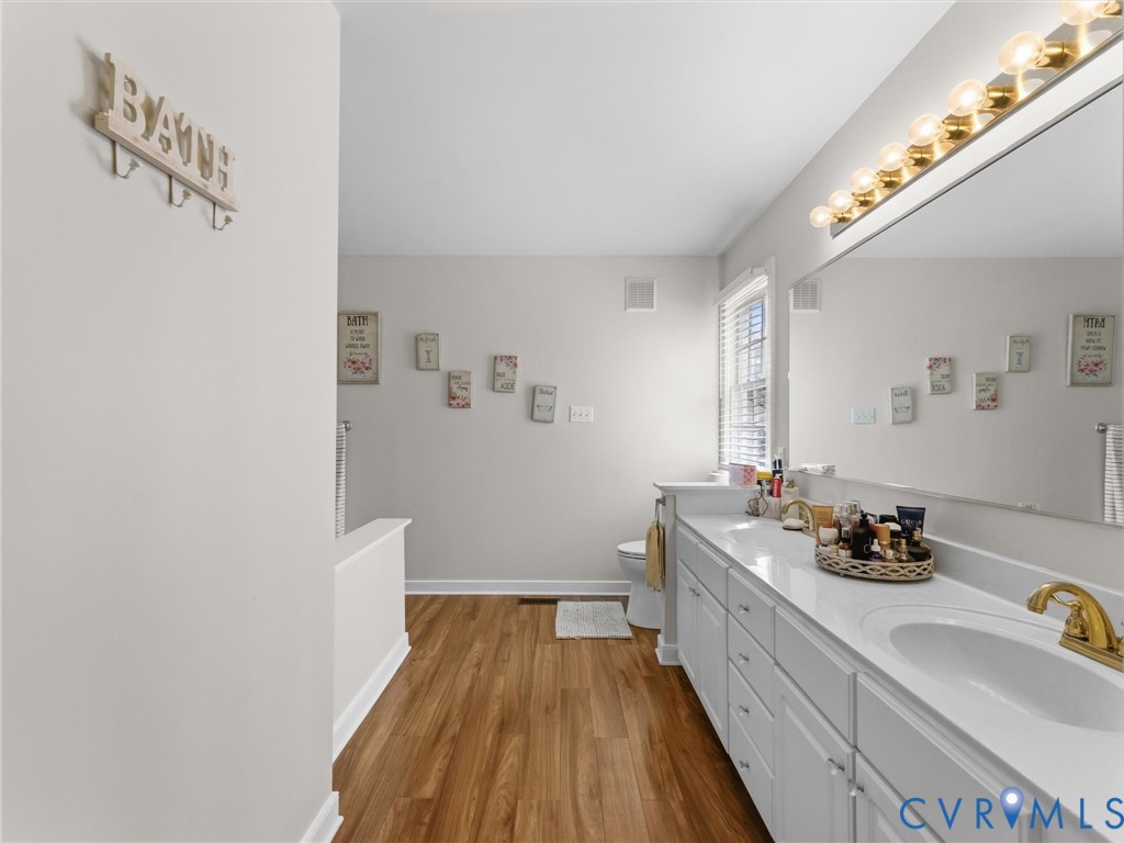 Double vanity with white cabinetry, gold-tone fixtures, and a spacious countertop