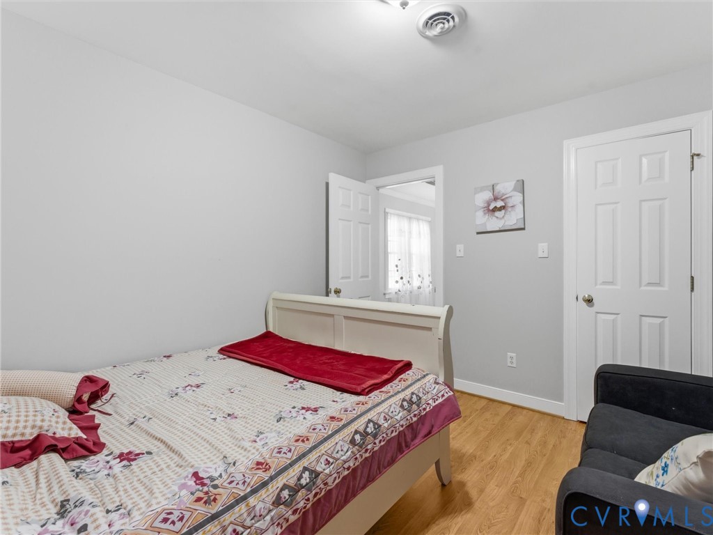 Wood-finish flooring, white paneled doors, and light gray wall paint