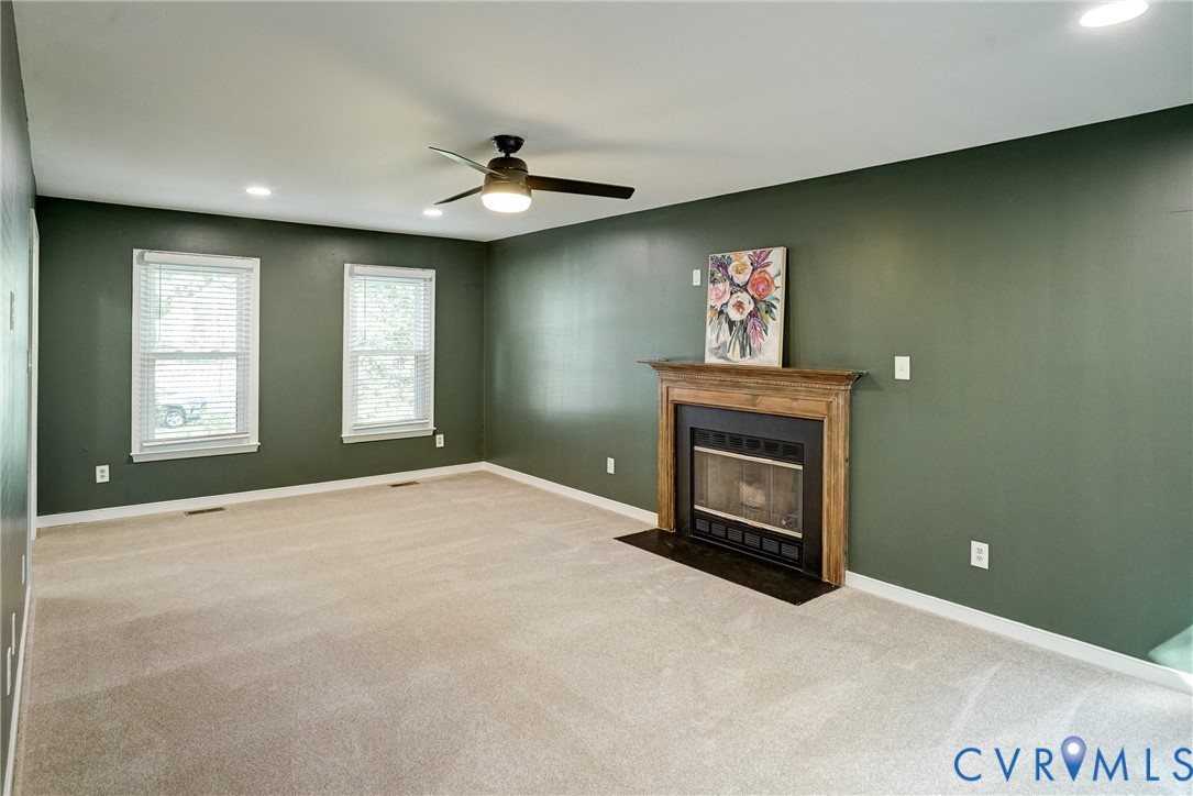 Living room with gas fireplace and recessed lighting.