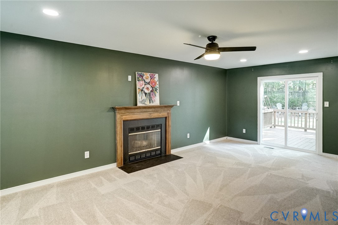 Spacious living room has new carpet and new sliding glass doors leading to backdeck