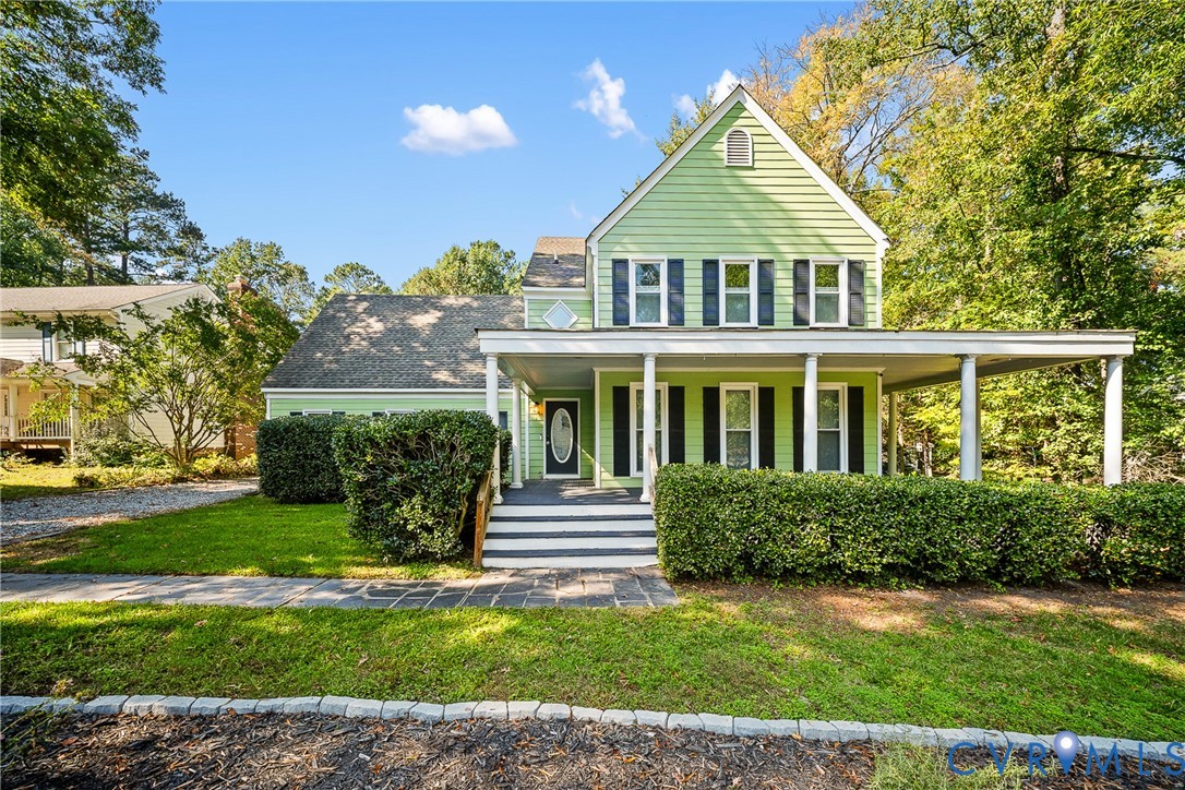 Two-story exterior featuring light-toned horizontal siding, a wrap-around front porch with structural columns, multi-pane windows with dark shutters, and an asphalt shingle roof Two-story exterior featuring light-toned horizontal siding, a wrap-around front porch with structural columns, multi-pane windows with dark shutters, and an asphalt shingle roof