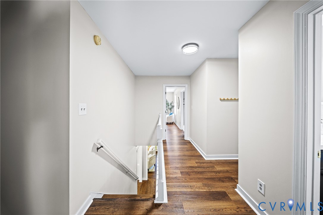 Hallway featuring wood-finish flooring, white walls, and a recessed ceiling light fixture