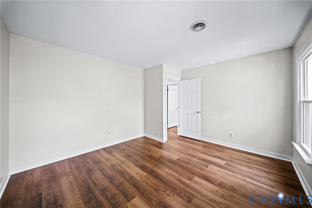 Neutral-toned walls, wood-finish flooring, and a multi-panel interior door