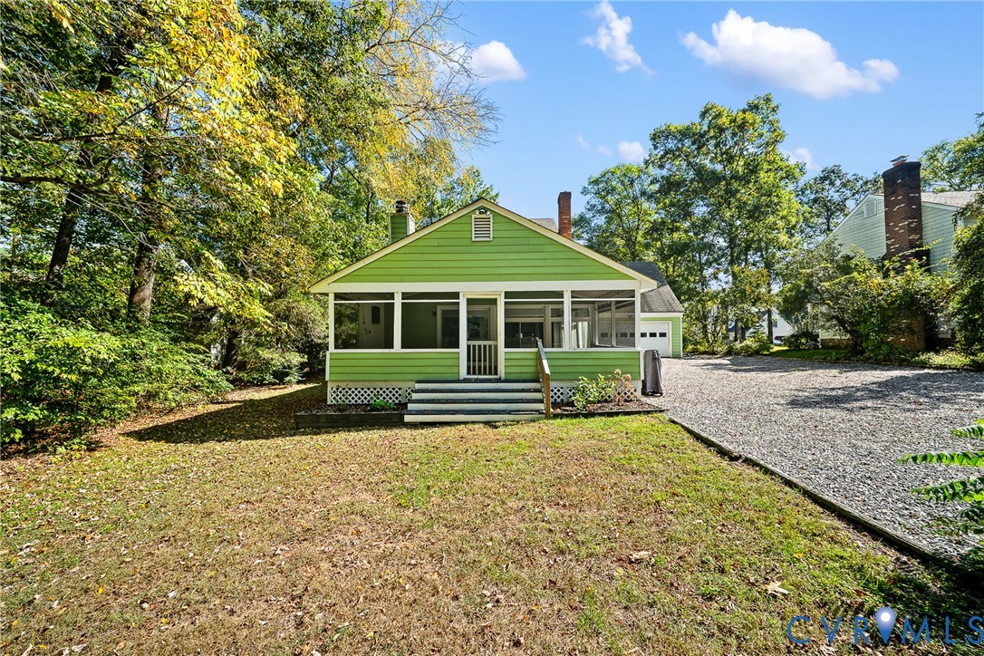 Screened porch with lap siding, exterior brick chimney, gravel driveway, and mature perimeter trees Screened porch with lap siding, exterior brick chimney, gravel driveway, and mature perimeter trees