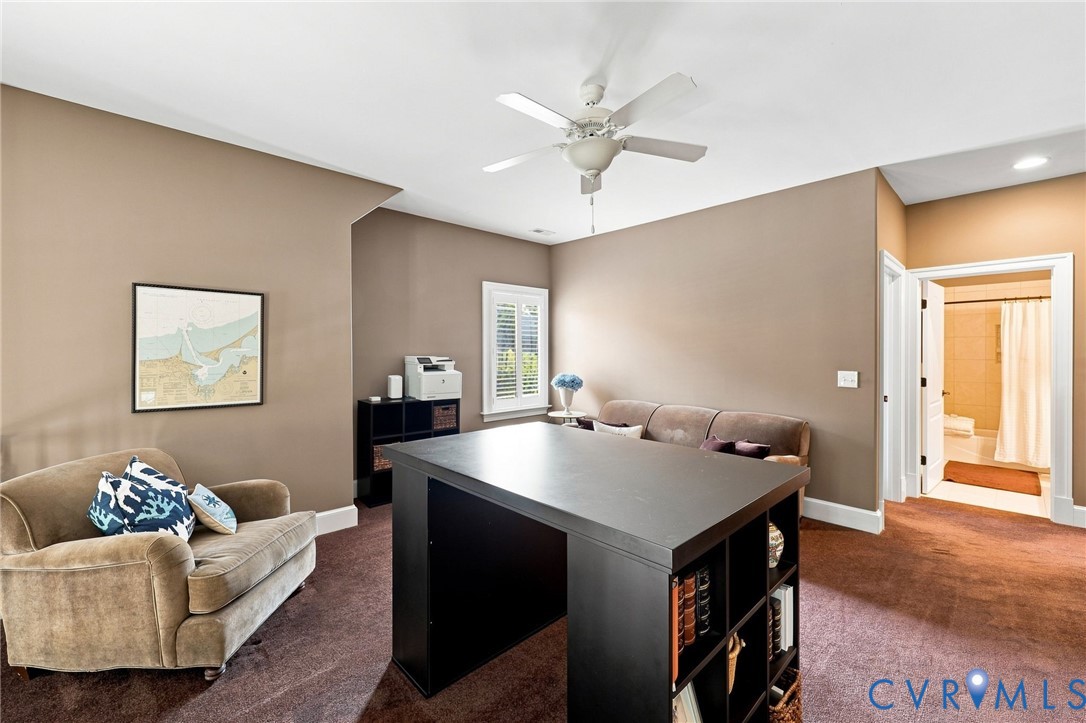 Carpeted room with neutral wall tones and a ceiling fan