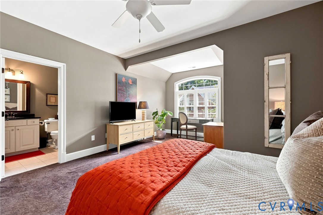 2nd primary suite on level 2, with arched window in sitting area (with shutters and solar film), and an attached bathroom featuring a raised height vanity with granite top and tub/shower combo
