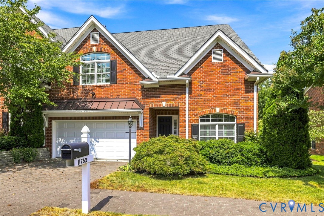 Brick exterior with white trim, a gabled roof, and black shutters
