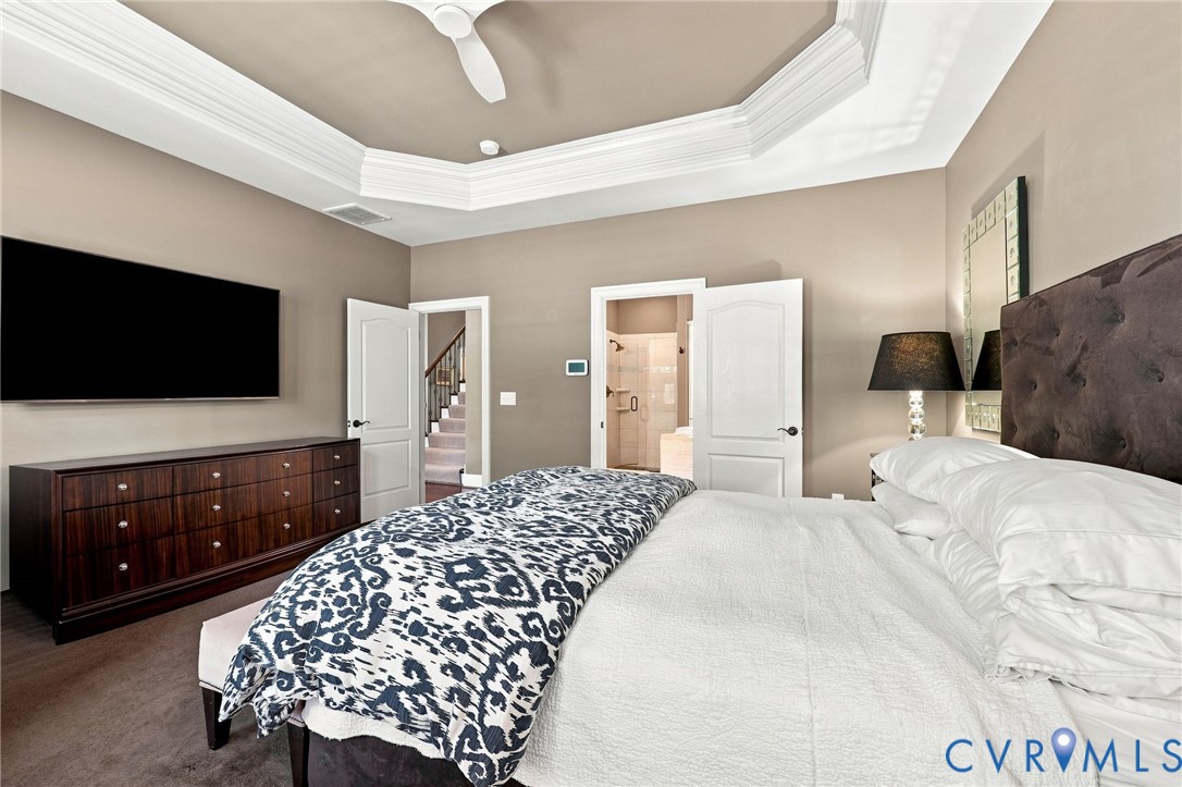 Tray ceiling with crown molding, ceiling fan, wood-finish flooring, and painted walls