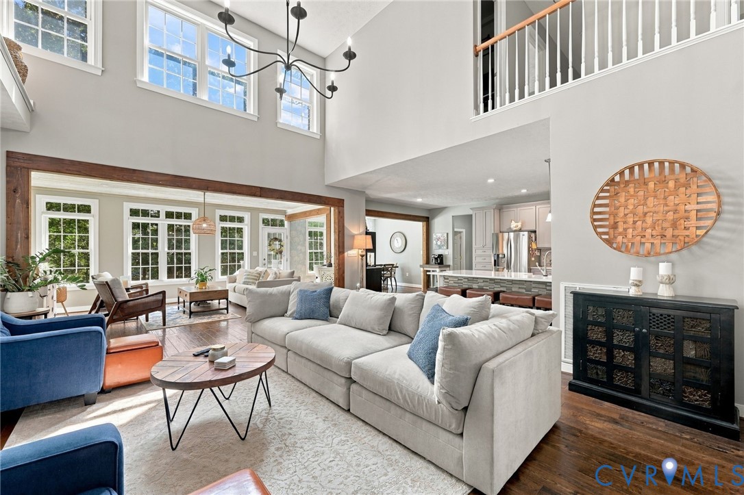 Two-story living area with high ceilings, dark wood-finish flooring, and an open-concept design
