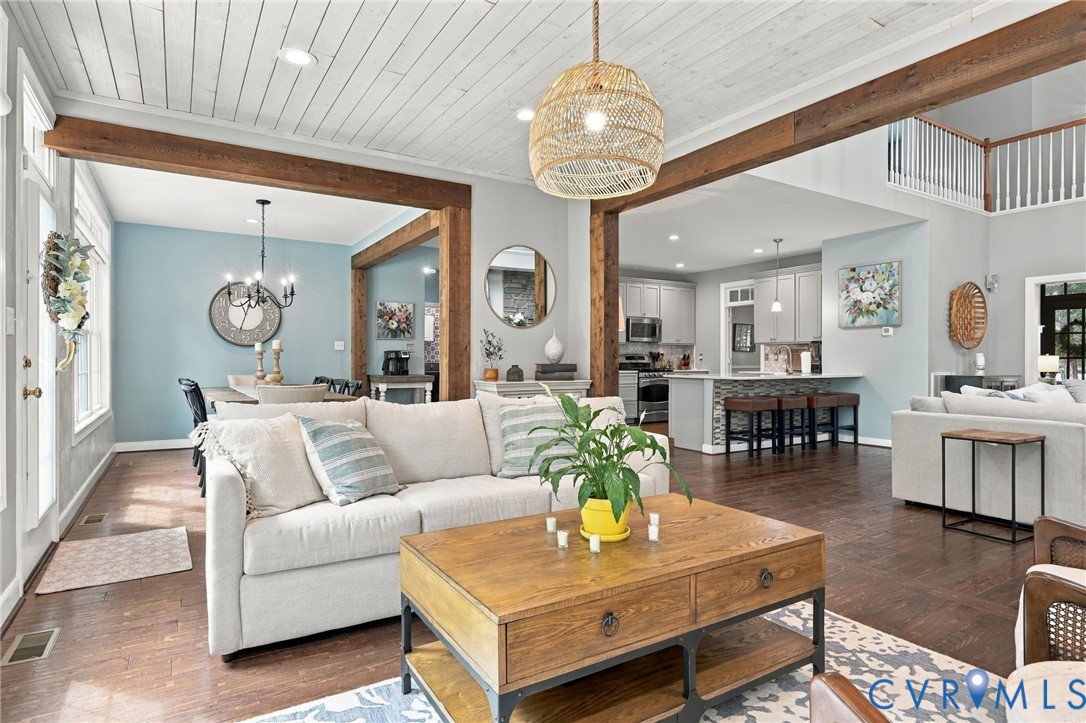 Wood-finish flooring throughout, exposed wood beams, and a white plank ceiling