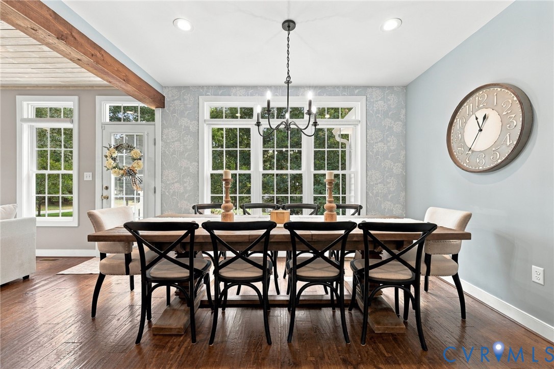 Elegant dining space anchored by a black rectangular table with coordinating X-back chairs, illuminated by a vintage-inspired pendant fixture