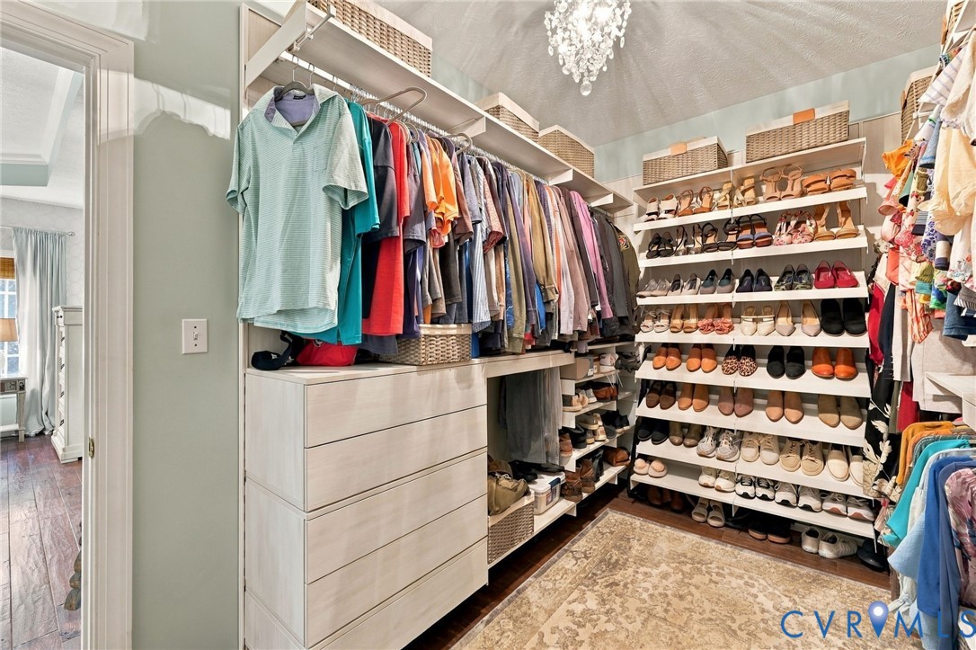 Custom closet system featuring multiple hanging rods, extensive shelving, and built-in drawers