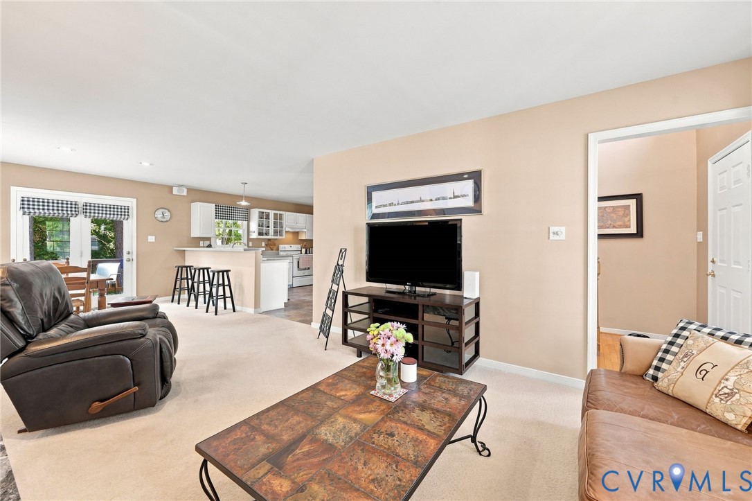 Recessed lighting, light-toned carpeting, and a white interior door