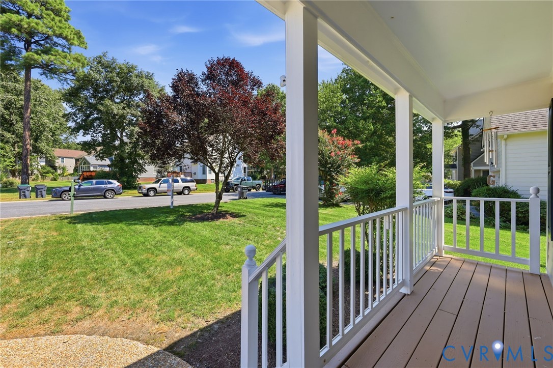 Covered front porch with white railings and composite decking