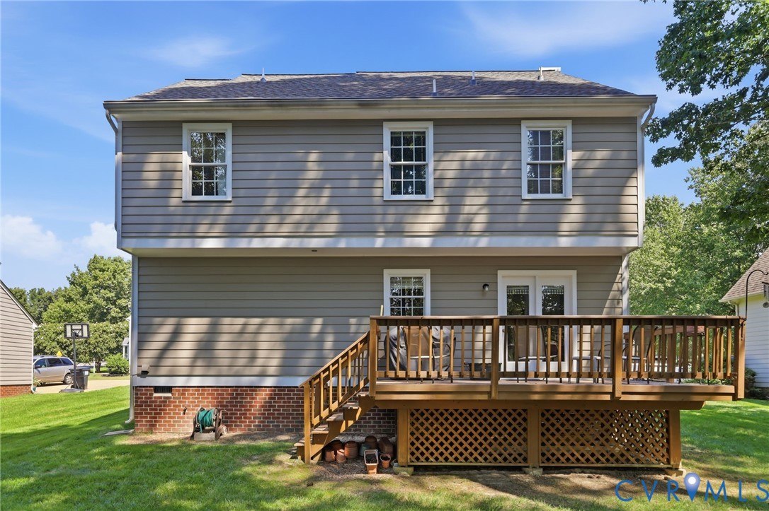 Two-story residential structure with horizontal siding, a gabled roof, and a wood deck featuring lattice skirting