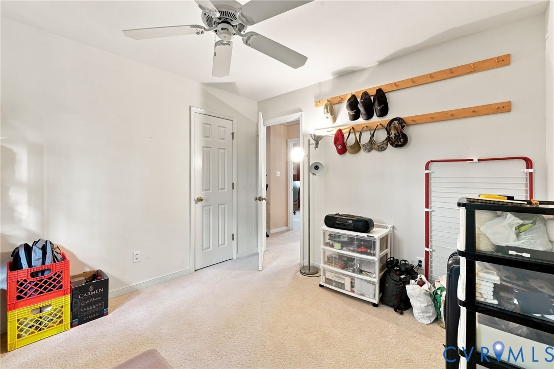 Neutral wall paint, ceiling fan with light fixture, paneled interior doors, and neutral carpet flooring