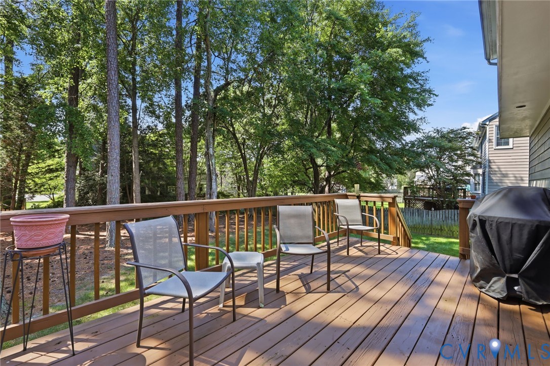Expansive wood-finish deck with railings, offering an outdoor living area