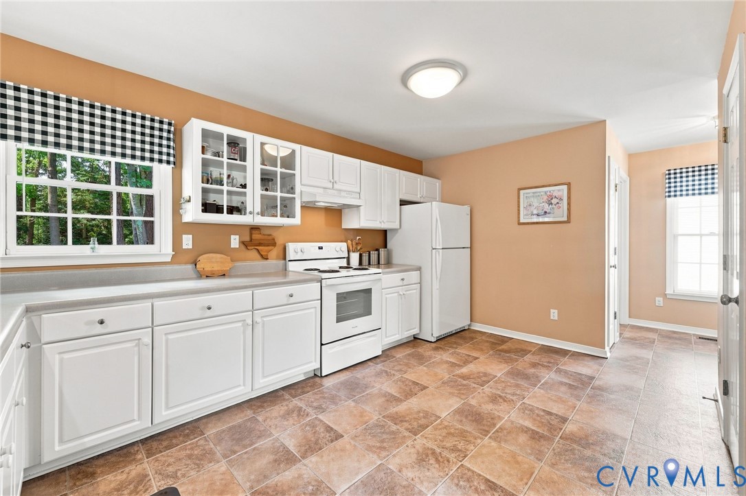 Kitchen featuring extensive white cabinetry, an electric range, a full-size refrigerator, and tile flooring