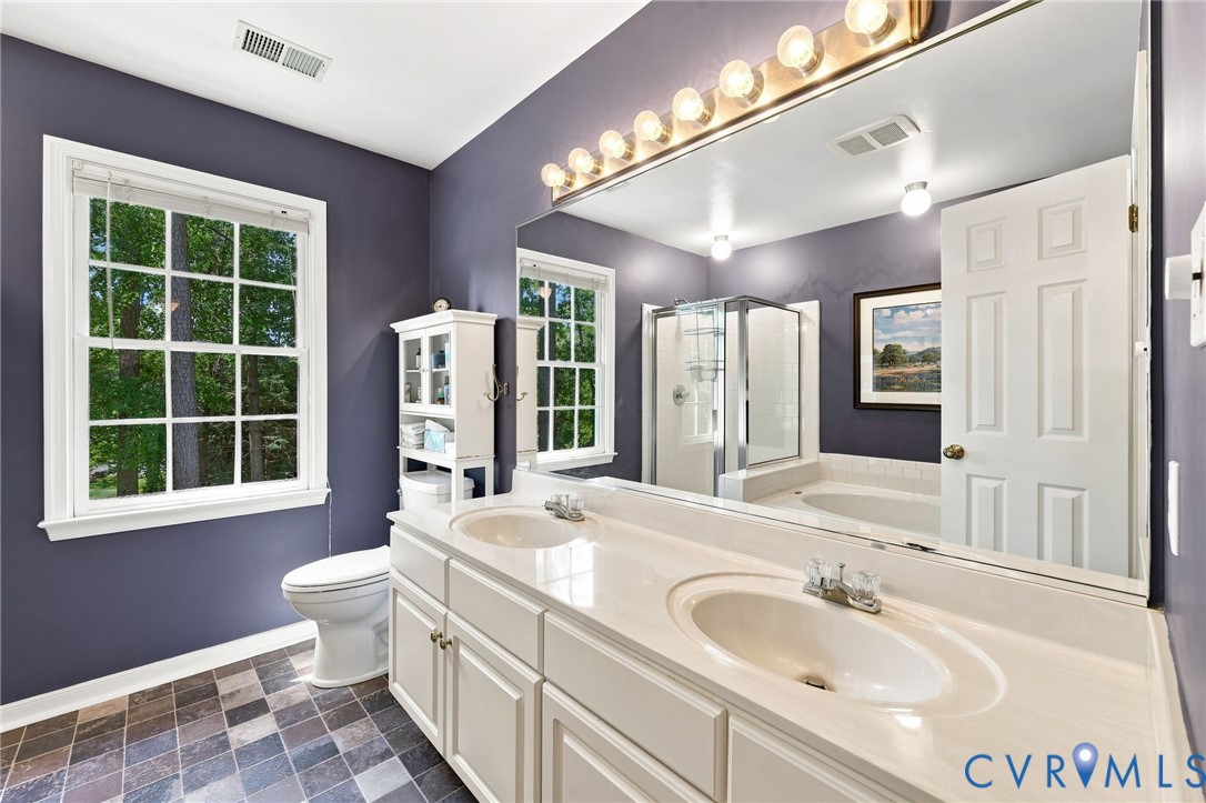 Dual vanity with integrated sinks, full-width mirror, and overhead strip lighting