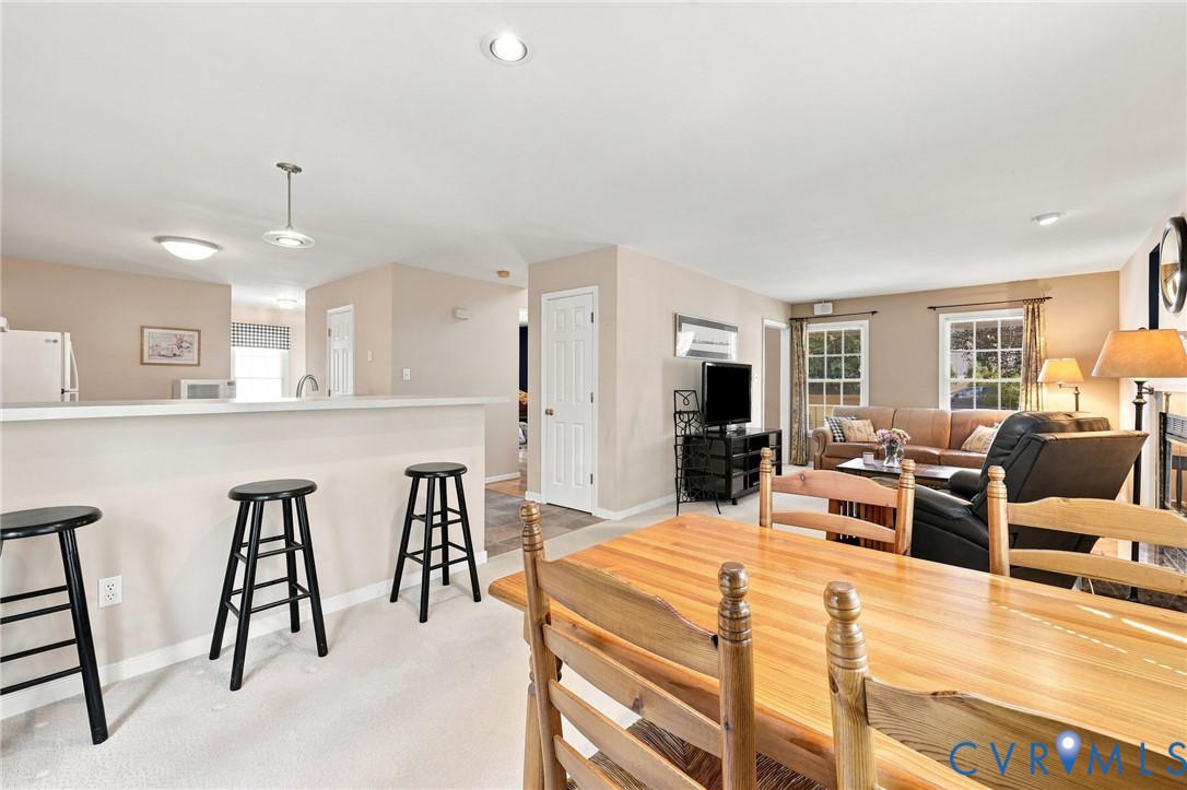 Open-concept living space with light-colored walls and carpeted flooring