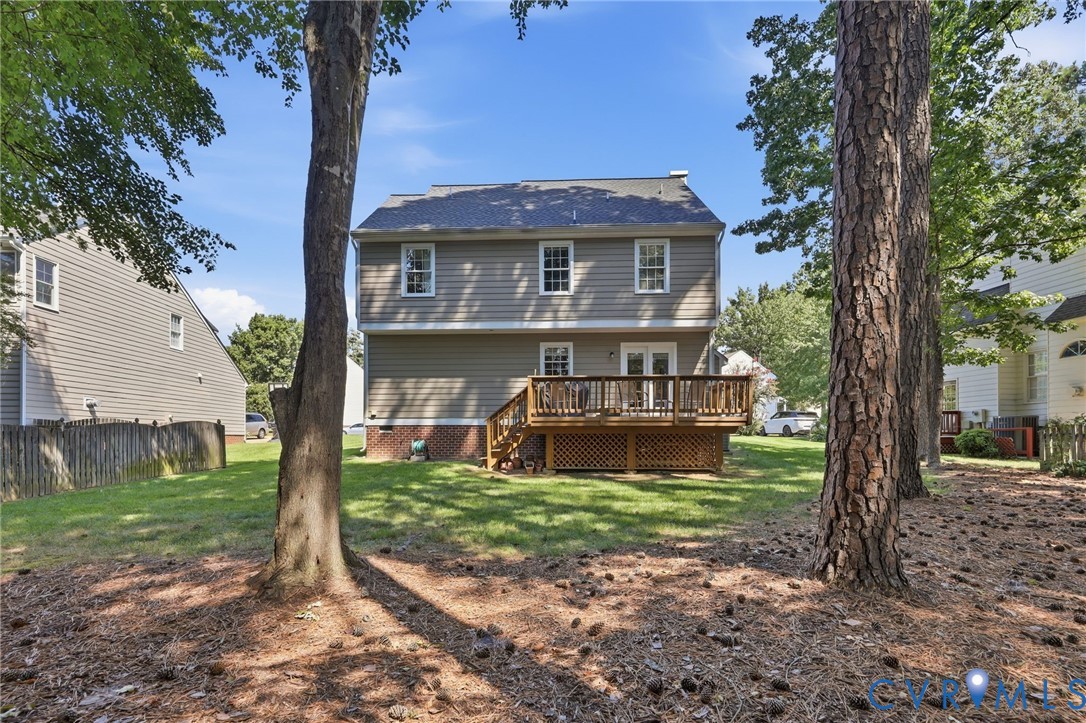 Two-story exterior with siding, a gabled roof, and a wood-tone deck