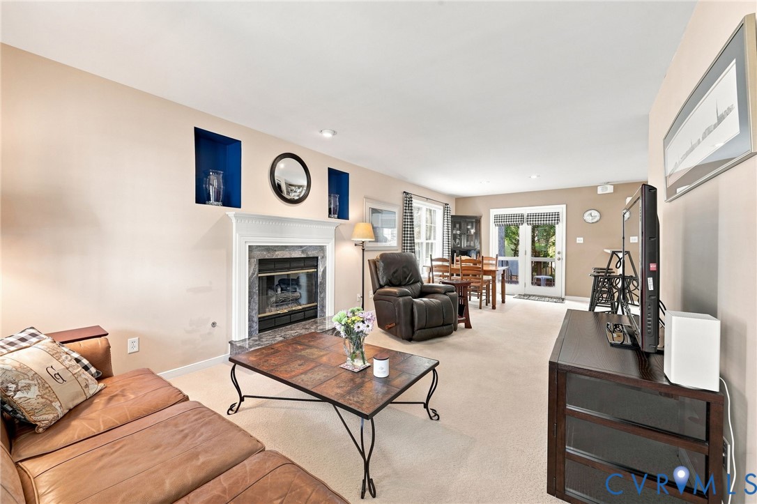 Living area with a fireplace featuring a stone surround and a white mantel