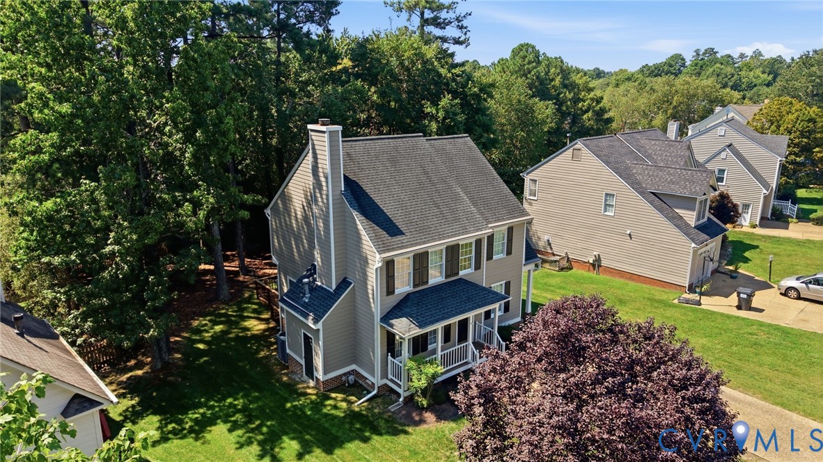 Two-story residence featuring siding exterior, a front porch, and a prominent chimney