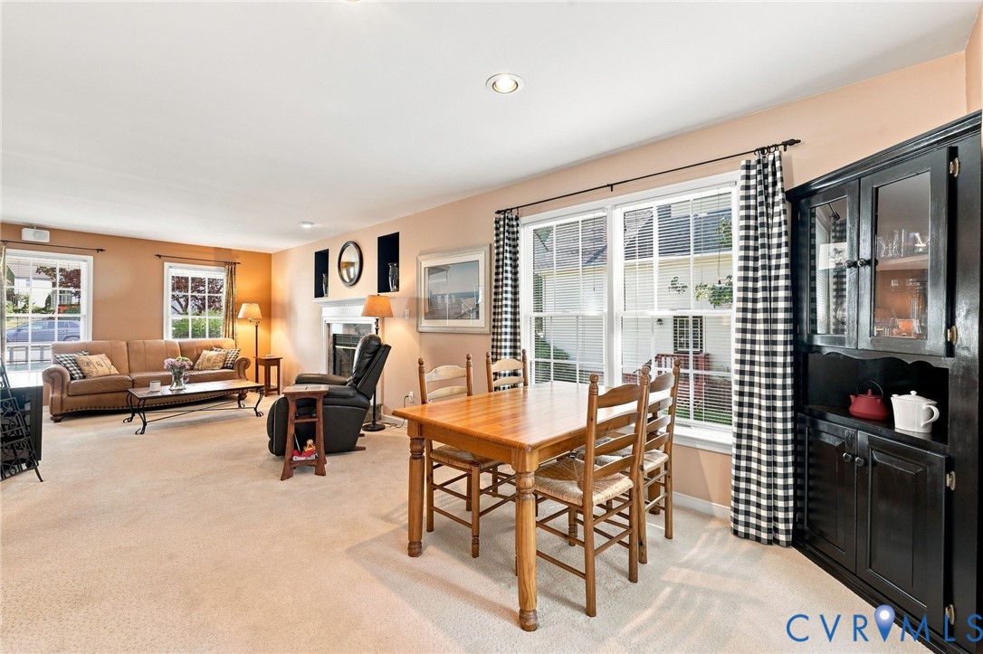 Recessed ceiling lighting, fireplace with mantel, built-in display cabinetry, and double-hung windows