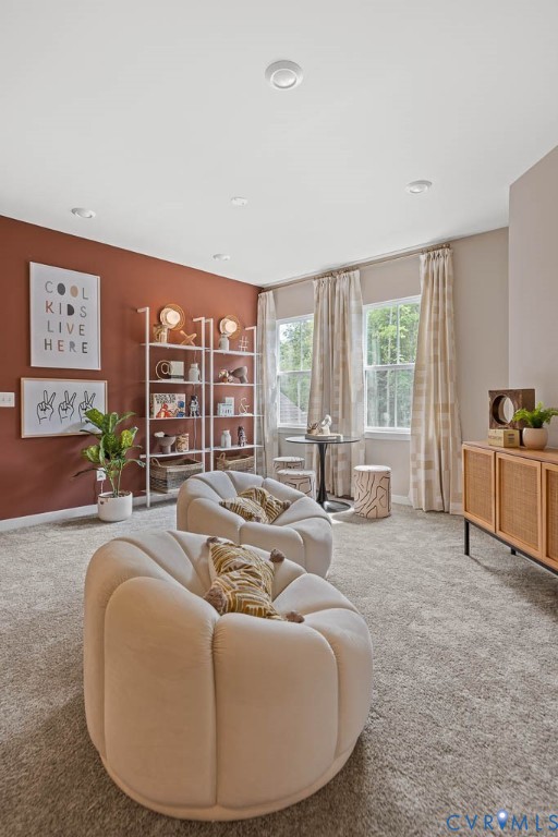 Recessed ceiling lighting, soft carpet flooring, multiple windows, built-in shelving, and a statement wall